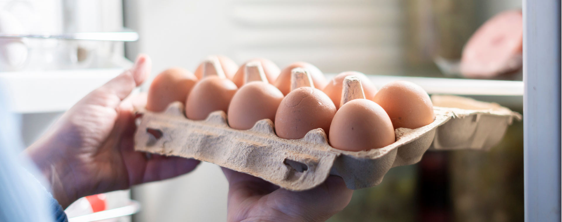 Woman pulling an open carton of brown eggs out of a refrigerator