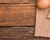 Brown eggs laying on linen on the right side of a wood tabletop